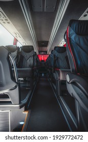 A Vertical Wide-angle View Of An Empty Interior Of A Regular Intercity Bus With Rows Of Leather Numbered Seats With Red Borders, Carpeted Seat Aisle In The Center