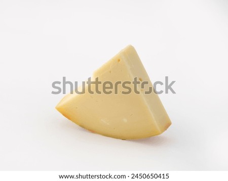vertically positioned wedge slice of typical Italian spicy provolone cheese on isolated white background