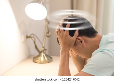 Vertigo illness concept. Man hands on his head felling headache dizzy sense of spinning dizziness,a problem with the inner ear, brain, or sensory nerve pathway.