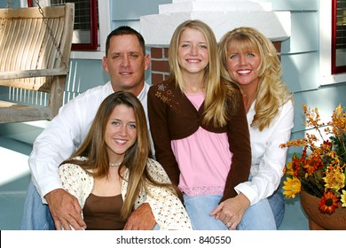 A Very Attractive Family On The Front Porch Of Their Home.