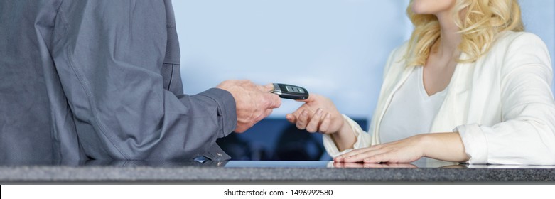 A Very Attractive Young Blonde Women Get Her Car Keys Back At The Counter Of The Tire And Car Service Workshop From The Mechanical Employee Of The Succesfull Service And Looks Very Satisfied And Happy