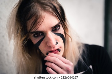 Very Authentic Young Punk Emo Man Looking Directly In Camera. Head And Shoulders Portrait Of Nose Pierced And Face Painted Guy. 