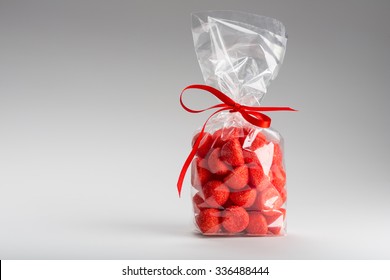 Very Beautiful And Candy Strawberries Bag Isolated On Grey Background. Left Copy Space. Fun Composition And Lighting. Shooting In Studio.