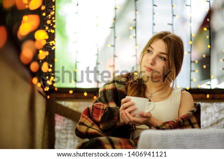 a very beautiful girl is sitting in a cafe, gazing straight ahead and beckoning to her charming look