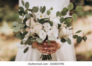 Very beautiful wedding bridal bouquet, made of white roch and austoma, and yellow daisies, green casting of eucalyptus.  Wedding, engagement. Bride and groom. Bride's wedding bouquet. - Shutterstock ID 2103037396
