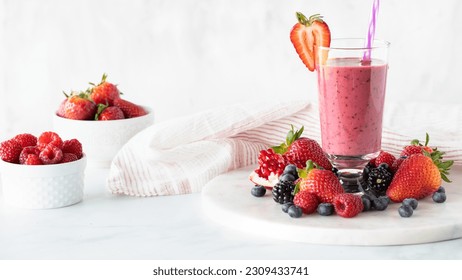 A very berry smoothie surrounded by berries and garnished with a strawberry. - Powered by Shutterstock