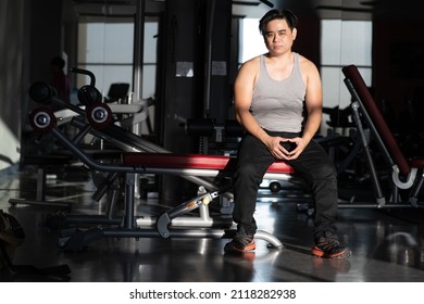 I Am Very Boredom In This Place, Short Hair Asian Man Look Strong Wear Grey Tank Top Black Plant Orange Snaker Sitting On Exercise Equipment Get Boring During Workout
