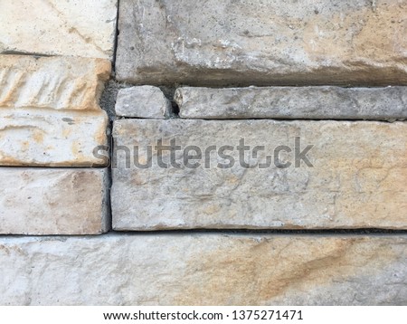 Very close up on the surface of some rocks from a rectangular stonework wall.