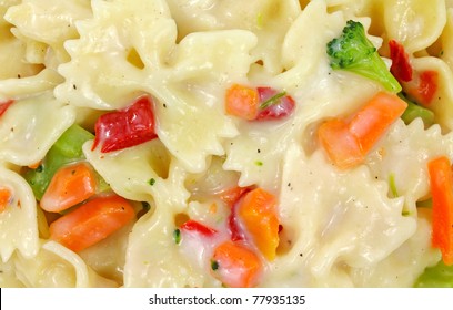 A Very Close View Of Bow Tie Style Pasta With Vegetables In Sauce.