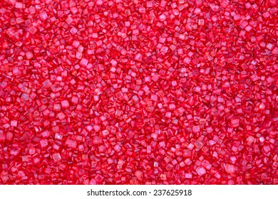A very close view of ruby red candy sugar sprinkles.