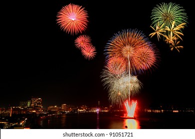 very colorful fireworks launched at a floating barge