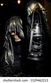 A Very Creepy Skeleton That Holds A Lamp In His Hand On A Black Background.