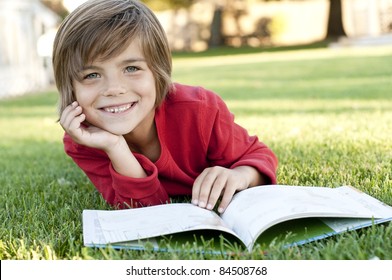  Very Cute 7 Year Old Boy Lying On The Grass Reading A Kids Book