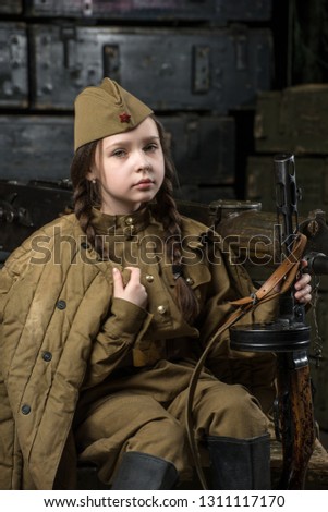 Very cute girl dressed in military uniform. She has a red star on her hat