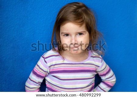 A very cute little girl with Chicken Pox looks at the camera with a mischievous look as if she is plotting something.