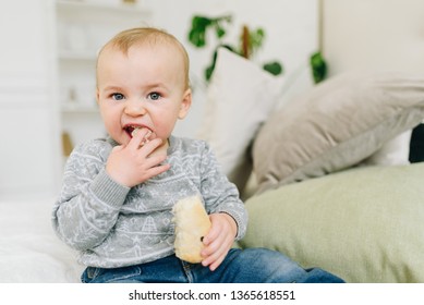 Very Cute Little Toddler Boy Snacking. Baby Or Small Child Eating A Piece Of Bread. Making Funny Silly Face.