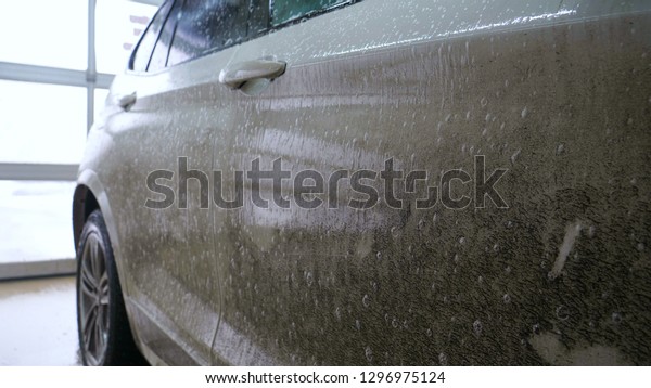 A\
very dirty car at the car wash will wash the whole body and remove\
dirt and then cover it with protective means. Concept of: Luxury\
car wash, Premium, To shine, Very Dirty, White\
car.