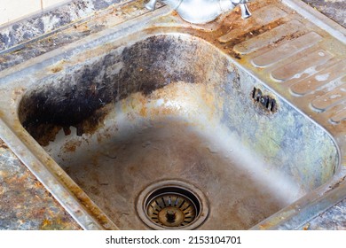 Very Dirty Kitchen Sink. Detergents For The Cooking Room. The Kitchen And Dishwashing Area Need To Be Cleaned With A Cleaning Agent. Cleaning The Kitchen Sink. Old Faulty Water Faucet. Close-up