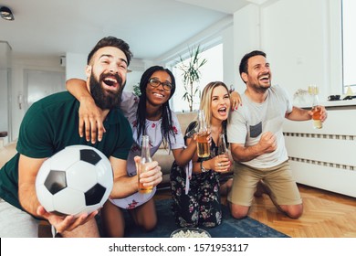 Very Excited Friends Having Fun By Watching Football Match, Drinking Beer And Eating Popcorn At Home 