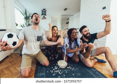 Very Excited Friends Having Fun By Watching Football Match, Drinking Beer And Eating Popcorn At Home 