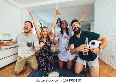 Very Excited Friends Having Fun By Watching Football Match, Drinking Beer And Eating Popcorn At Home 