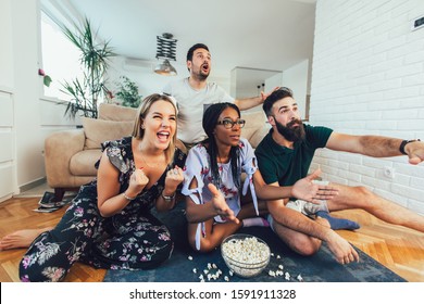 Very Excited Friends Having Fun By Watching Football Match, Drinking Beer And Eating Popcorn At Home 