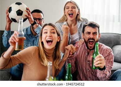 Very Excited Friends Having Fun By Watching Football Match At Home.They Are Celebrating Goal.