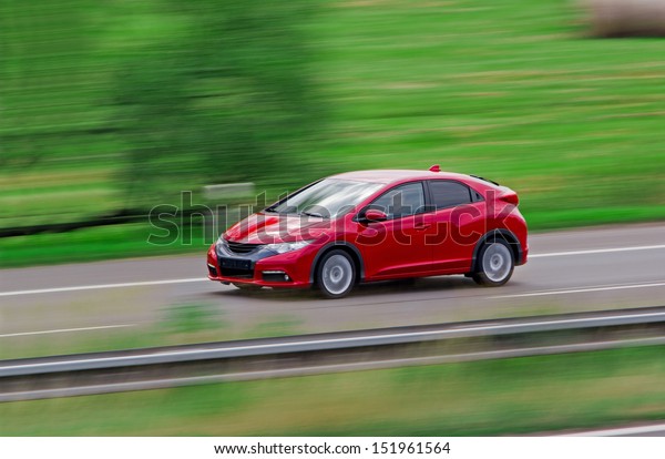 Very fast\
driving red Japanese modern\
hatchback