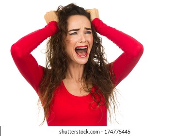 A very frustrated and angry and upset woman is screaming out loud and pulling her hair. Isolated on white.