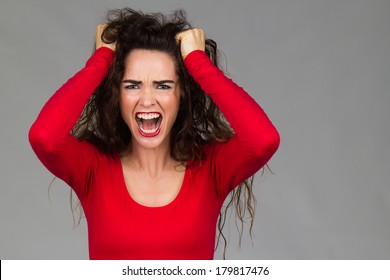 A Very Frustrated And Angry Woman Is Pulling Her Hair And Screaming.