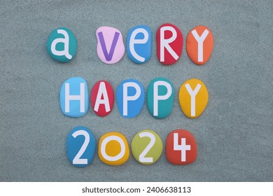 A very happy 2024 composed with hand painted multi colored stone letters and numbers over green sand