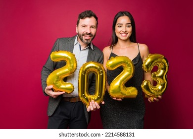 Very happy attractive latin couple wearing a suit and a formal dress holding a 2023 ballons for new year's eve - Shutterstock ID 2214588131