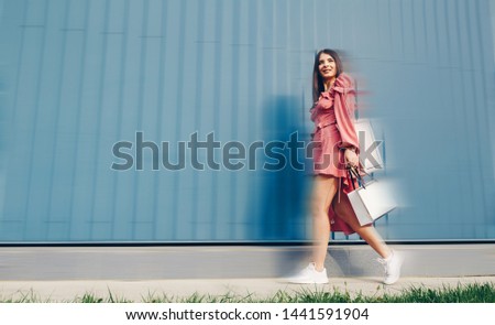 Very happy beautiful young woman in casual clothing with shopping bags, with copyspace area for text or slogan