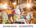 
Very happy children ride in a nostalgic horse carousel that is deliberately blurred by movement