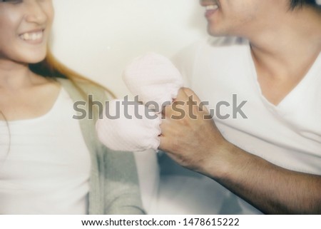 Very happy family concept : Close up hand young family couples, playful, take the baby's white gloves, tease with fun and happy smiles.


