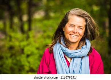 A very happy middle aged woman, outside in the nature, Sweden