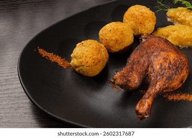 Very healthy roast duck thigh with potatoes and greens on a black plate on a wooden table serving in a restaurant. nice decoration of the dish. diet food in a restaurant side view