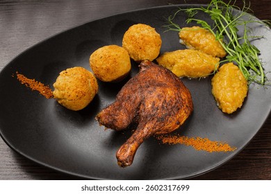 Very healthy roast duck thigh with potatoes and greens on a black plate on a wooden table serving in a restaurant. nice decoration of the dish. diet food in a restaurant