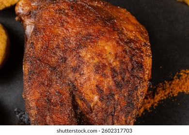 Very healthy roast duck thigh with potatoes and greens on a black plate on a wooden table serving in a restaurant. nice decoration of the dish. macro photography duck