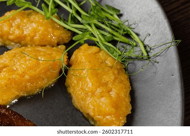Very healthy roast duck thigh with potatoes and greens on a black plate on a wooden table serving in a restaurant. nice decoration of the dish. macro shooting