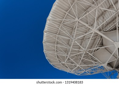 Very Large Array engineering understructure of a very large radio telescope dish against a vivid blue sky, copy space, science technology, horizontal aspect