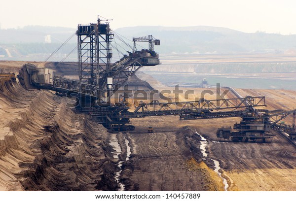 A very large bucket-wheel excavator and conveyor\
belt in a brown-coal mine