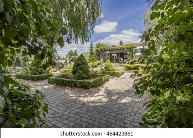 Very Large Garden With Sett Pathways, And A Detached House In The Background