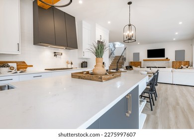Very large spacious kitchen with additional spice wok kitchen long white countertop with eating area dark grey service area with wine fridge glass cabinet shelving farmhouse sink