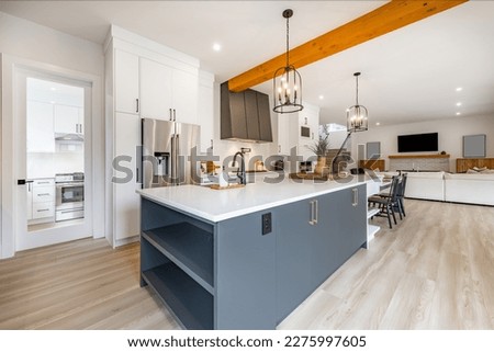 Very large spacious kitchen with additional spice wok kitchen long white countertop with eating area dark grey service area with wine fridge glass cabinet shelving farmhouse sink