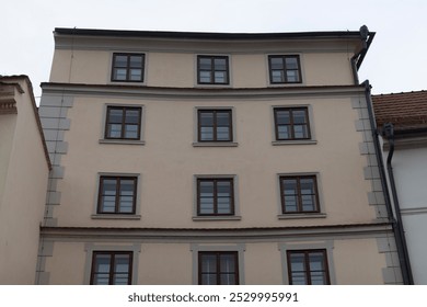 A very large structure that features numerous windows all across its facade, making it appear bright and spacious from the outside