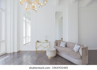 very light and bright interior of luxurious cozy living room with chic soft beige furniture with gold metallic elements, huge window to the floor and wooden parquet - Shutterstock ID 1961931445