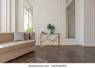 very light and bright interior of luxurious cozy living room with chic soft beige furniture with gold metallic elements, huge window to the floor and wooden parquet - Shutterstock ID 1963568302