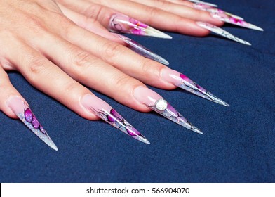 Very long artificial nails at dark background