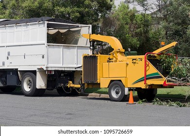 Very noisy tree shredder makes useful mulch out of unwanted tree branches           - Shutterstock ID 1095726659